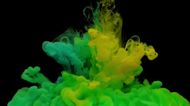 カラフルな緑と黄色のインクが水中に混ざり合い コピースペースを持つ黒い背景に静かに水中を旋回 塗料の着色されたアクリル雲が分離しました 抽象的な煙の爆発アニメーション 宇宙スローモーション — ストック動画