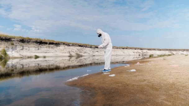 Mann Schutzanzug Und Gasmaske Kommt Verschmutzten Fluss See Und Nimmt — Stockvideo