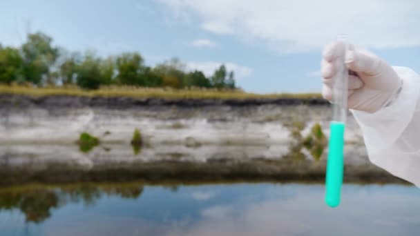 보호복을 남자의 오염된 강이나 호수에서 분석한 시험관을 보여줍니다 과학자는 시험관에서 — 비디오
