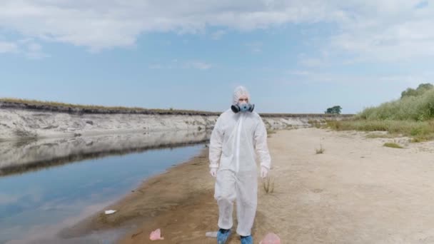 Человек Защитном Костюме Респираторе Ходит Сухой Реке Оценивает Степень Загрязнения — стоковое видео