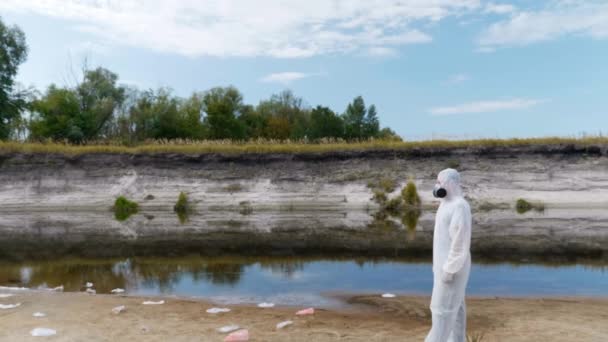 Hombre Traje Protección Respirador Encuentra Entre Basura Plástico Cerca Río — Vídeo de stock