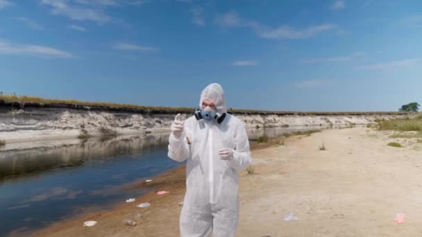 Человек Защитном Костюме Респираторе Наблюдает Химическую Реакцию Воды Пробирке Которую — стоковое видео