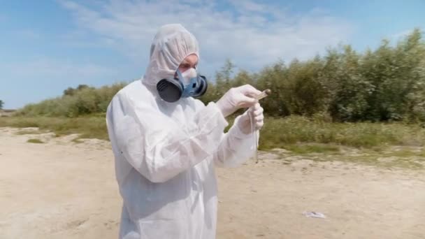 Hombre Con Traje Protector Respirador Observa Una Reacción Química Del — Vídeos de Stock