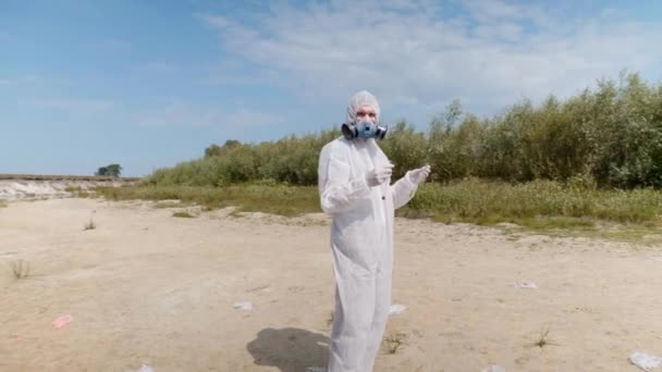 Man Protective Suit Respirator Vitro Standing Beach Next Dried River — Stock Video