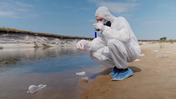 身着防护服和呼吸器的人观察试管中水的化学反应 他从被污染的河流中进行分析 科学家在体外取样 生态灾难 — 图库视频影像