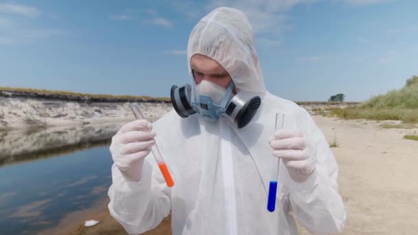 Mann Schutzanzug Und Atemmaske Beobachtet Eine Chemische Reaktion Des Wassers — Stockvideo