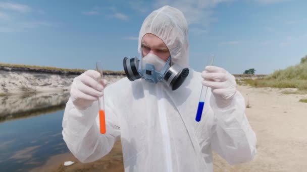 Homem Traje Protetor Respirador Observa Uma Reação Química Água Tubo — Vídeo de Stock
