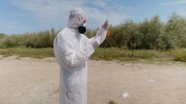 Людина Захисному Костюмі Респіратор Спостерігає Хімічну Реакцію Води Пробірці Яку — стокове відео