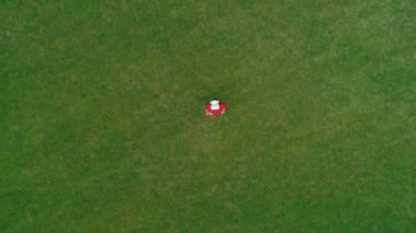 Kafasında Vr kulaklığı olan ve parktaki kameraya bakan adamın havadan görüntüsü. Kasklı genç adam doğanın arka planında artırılmış gerçeklik yaşıyor. 4k drone görüntüleri.