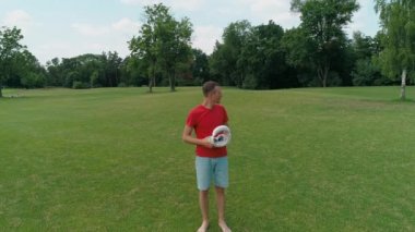 Bir adam kafasına vr kulaklık takıyor ve parka bakıyor. Kasklı genç adam doğanın arka planında artırılmış gerçeklik yaşıyor. 4k drone görüntüleri.