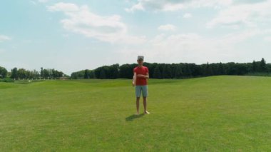 Vr kulaklığına koyup parkta elini sallayan adamın havadan görünümü. Kasklı genç adam doğanın arka planında artırılmış gerçeklik yaşıyor. 4k drone görüntüleri.