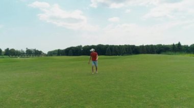 Vr kulaklık kullanan ve parkta sanal bir oyun oynayan bir adam. Kasklı genç adam doğanın arka planında artırılmış gerçeklik yaşıyor. Çerçevenin sağ tarafında bir insan var. 4k drone görüntüleri.