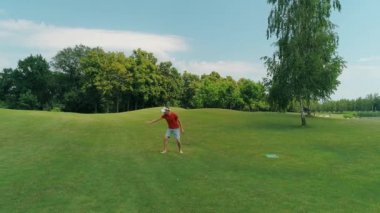 Vr kulaklık kullanan ve parkta sanal bir oyun oynayan bir adam. Kasklı genç adam doğanın arka planında artırılmış gerçeklik yaşıyor. Çerçevenin sağ tarafında bir insan var. 4k drone görüntüleri.