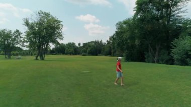 Vr kulaklık kullanan ve parkta sanal bir oyun oynayan adamın havadan görünümü. Kasklı genç adam doğanın arka planında artırılmış gerçeklik yaşıyor. 4k drone görüntüleri.