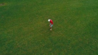 Vr kulaklık kullanan ve parkta sanal bir oyun oynayan adamın havadan görünümü. Kasklı genç adam doğanın arka planında artırılmış gerçeklik yaşıyor. 4k drone görüntüleri.