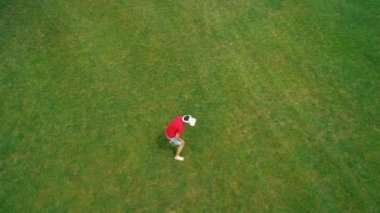 Vr kulaklık kullanan ve parkta sanal bir oyun oynayan adamın havadan görünümü. Kasklı genç adam doğanın arka planında artırılmış gerçeklik yaşıyor. 4k drone görüntüleri.