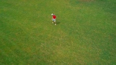 Vr kulaklık kullanan ve parkta sanal bir oyun oynayan adamın havadan görünümü. Kasklı genç adam doğanın arka planında artırılmış gerçeklik yaşıyor. 4k drone görüntüleri.