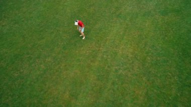 Vr kulaklık kullanan ve parkta sanal bir oyun oynayan adamın havadan görünümü. Kasklı genç adam doğanın arka planında artırılmış gerçeklik yaşıyor. 4k drone görüntüleri.