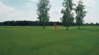 Vr kulaklık kullanan ve parkta sanal bir oyun oynayan bir adam. Kasklı genç adam doğanın arka planında artırılmış gerçeklik yaşıyor. Çerçevenin sağ tarafında bir insan var. 4k drone görüntüleri.