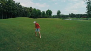 Vr kulaklık kullanan ve parkta sanal bir oyun oynayan bir adam. Kasklı genç adam doğanın arka planında artırılmış gerçeklik yaşıyor. Çerçevenin sağ tarafında bir insan var. 4k drone görüntüleri.