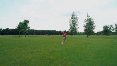 Vr kulaklık kullanan ve parkta sanal bir oyun oynayan bir adam. Kasklı genç adam doğanın arka planında artırılmış gerçeklik yaşıyor. Çerçevenin sağ tarafında bir insan var. 4k drone görüntüleri.