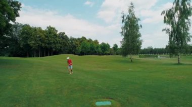 Vr kulaklık kullanan ve parkta sanal bir oyun oynayan bir adam. Kasklı genç adam doğanın arka planında artırılmış gerçeklik yaşıyor. Çerçevenin sağ tarafında bir insan var. 4k drone görüntüleri.