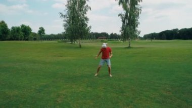 Vr kulaklık kullanan ve parkta sanal bir oyun oynayan bir adam. Kasklı genç adam doğanın arka planında artırılmış gerçeklik yaşıyor. Çerçevenin sağ tarafında bir insan var. 4k drone görüntüleri.