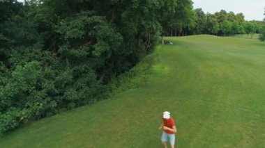 Vr kulaklık kullanan ve parkta sanal bir oyun oynayan adamın havadan görünümü. Kasklı genç adam doğanın arka planında artırılmış gerçeklik yaşıyor. 4k drone görüntüleri.