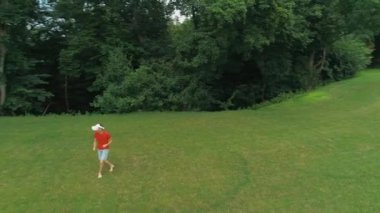 Vr kulaklık kullanan ve parkta sanal bir oyun oynayan adamın havadan görünümü. Kasklı genç adam doğanın arka planında artırılmış gerçeklik yaşıyor. 4k drone görüntüleri.