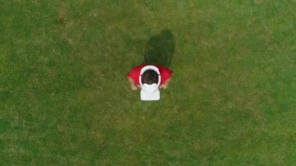 Luftaufnahme eines Mannes mit einem Vr-Headset auf dem Kopf, der im Park in die Kamera blickt. junger Mann mit Helm, der Augmented Reality vor dem Hintergrund der Natur erlebt. 4k Drohnenaufnahmen.