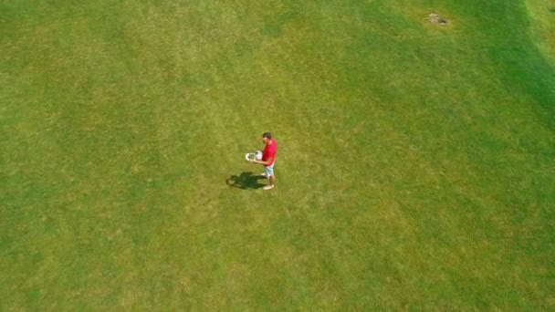 아름다운 나무와 화창한 구름이있는 사이에 잔디를 서있는 헤드셋을 들고있는 사람의 — 비디오