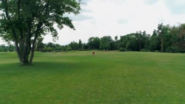 Vr kulaklık kullanan ve parkta sanal bir oyun oynayan adamın havadan görünümü. Kasklı genç adam doğanın arka planında artırılmış gerçeklik yaşıyor. 4k drone görüntüleri.