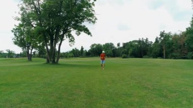 Vr kulaklık kullanan ve parkta sanal bir oyun oynayan bir adam. Kasklı genç adam doğanın arka planında artırılmış gerçeklik yaşıyor. Çerçevenin sağ tarafında bir insan var. 4k drone görüntüleri.