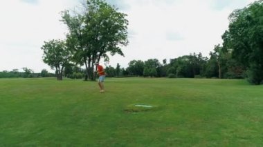 Vr kulaklık kullanan ve parkta sanal bir oyun oynayan bir adam. Kasklı genç adam doğanın arka planında artırılmış gerçeklik yaşıyor. Çerçevenin sağ tarafında bir insan var. 4k drone görüntüleri.