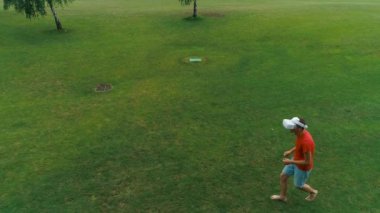 Vr kulaklık kullanan ve parkta sanal bir oyun oynayan adamın havadan görünümü. Kasklı genç adam doğanın arka planında artırılmış gerçeklik yaşıyor. 4k drone görüntüleri.