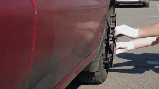 Inexperienced Man White Gloves Puts Cap Wheel His Broken Dirty — Stock Video