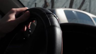 Sonbahar sezonunda araba kullanan deri ceketli bir adamın direksiyonuna yakın çekim. 4k görüntü.