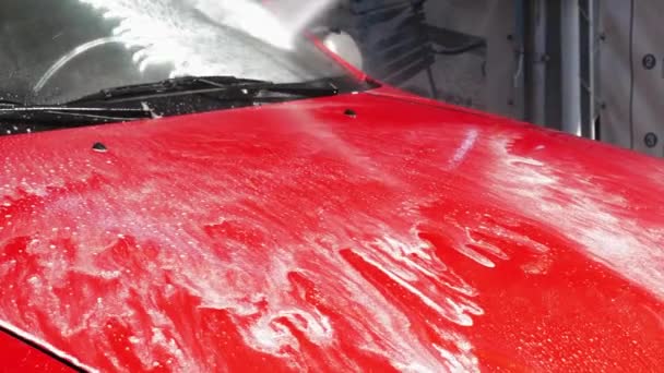 高圧の水のジェットは 車から汚れを洗い流します 発泡洗剤は 車のボンネットから排出されます 4Kフッテージ — ストック動画