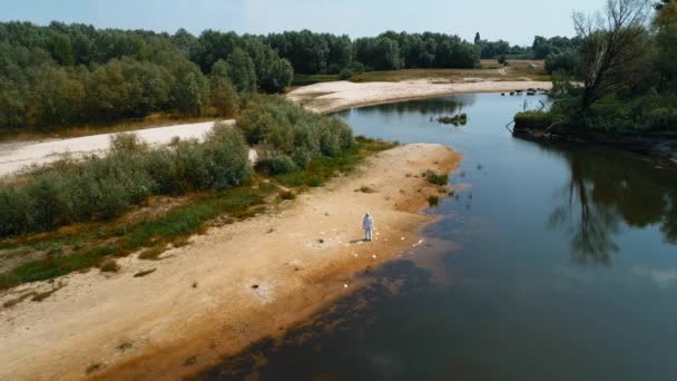 Flygfoto Man Skyddande Dräkt Och Andningsskydd Som Står Bland Plastavfall — Stockvideo