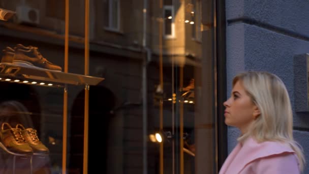 Молода Приваблива Блондинка Мріє Про Нову Покупку Біля Вікна Бутіка — стокове відео