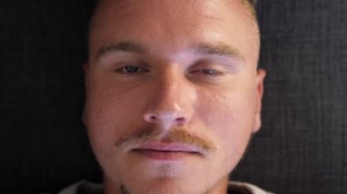 Göz damlası ilaç şifa uygulayan adamın yakın çekim görünümü. Genç adam gözüne sıvı ilaç damlattı. Sağlık göz hekimliği kavramı. Yaygın göz enfeksiyonu ve iltihaplanma. Yapay gözyaşları. 4k