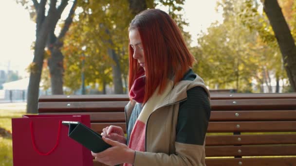 Parkta Ceketli Çekici Kızıl Saçlı Kadın Internetten Alışveriş Yapıyor Güneşli — Stok video