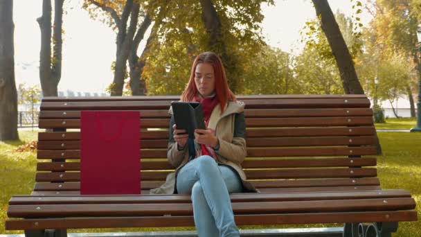 Jovem Atraente Mulher Cabelos Vermelhos Uma Jaqueta Parque Está Comprando — Vídeo de Stock