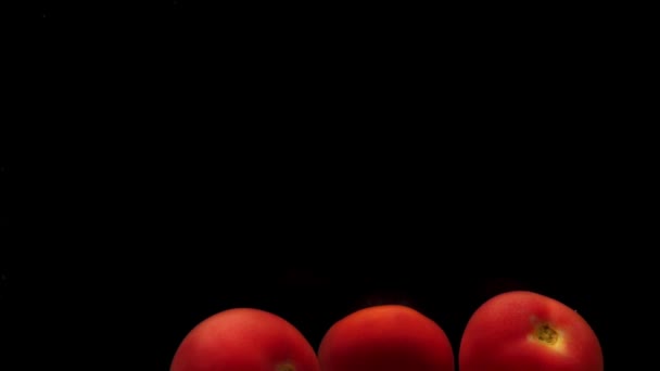 三个红色的番茄在透明的水中 黑色的背景 新鲜的有机蔬菜在水族馆里飞溅 杂货店 健康食品 空气泡泡 慢动作 后续行动 — 图库视频影像