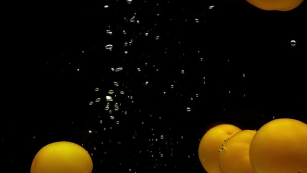 Fünf Gelbe Tomaten Die Transparentes Wasser Auf Schwarzem Hintergrund Fallen — Stockvideo