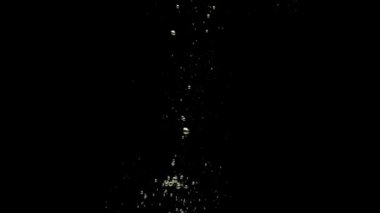 Yeşil salatalık siyah arkaplanda saydam suya düşüyor. Akvaryuma taze organik sebzeler sıçrıyor. Market, sağlıklı yiyecekler, diyet, vejetaryenlik, hava kabarcıkları. Ağır çekim. Yakın plan..