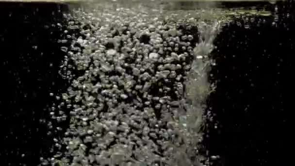 许多小气泡在水晶般清澈的水底下渗透 混合并上升 在黑色背景上用复制空间轻轻旋转 水下气泡会造成破坏 慢动作 后续行动 — 图库视频影像