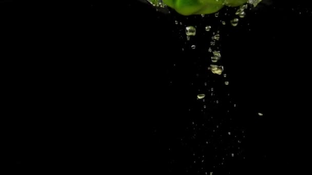 Ein Grüner Paprika Der Transparentes Wasser Auf Schwarzem Hintergrund Fällt — Stockvideo