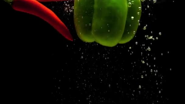 Chili Rojo Pimentón Verde Cayendo Agua Sobre Fondo Negro Verduras — Vídeo de stock