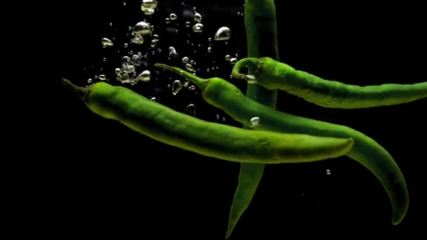 Зеленое Чили Падает Прозрачную Воду Черном Фоне Свежие Органические Овощи — стоковое видео